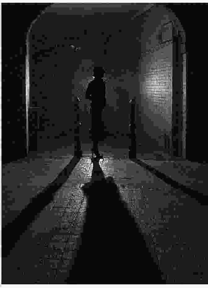 Batman Standing In A Dark Alleyway, Lit By A Single Street Lamp, With A Shadowy Figure Behind Him. Batman: Urban Legends (2024 ) #15 Mark Russell